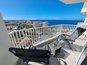 einen Balkon mit 2 Stühlen, einem Grill und Meerblick in der Unterkunft Panoramic Floor - Las Americas in Playa de las Americas