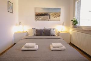 a bedroom with a bed with two towels on it at Apartament w sercu Swinoujscia z 3 sypialniami in Świnoujście