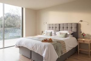 ein Schlafzimmer mit einem großen Bett und einem großen Fenster in der Unterkunft Topwood in Salcombe