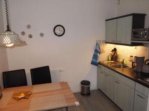 バート・ハルツブルクにあるFewo 3 Sterne Mit Harzblickのキッチン(テーブル、壁掛け時計付)