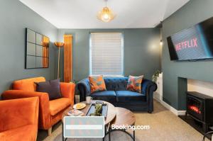 a living room with a blue couch and orange chairs at Contractors Accommodation South Wales By Rutland Stays Short Lets & Serviced Accommodation Pentre in Treorky