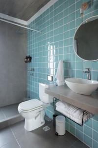 Baño de azulejos azules con aseo y lavamanos en Complejo il Pensiero Punta del Diablo, en Punta del Diablo