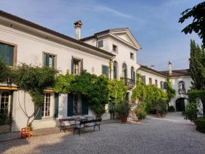 a courtyard of a building with benches and trees at Villa Di Tissano in Tissano