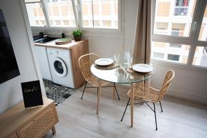 una piccola cucina con tavolo, sedie e lavatrice di LE PETIT LH - PLAGE - B'PAM a Le Havre Altre 7 foto