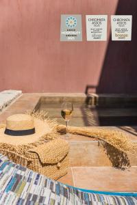 阿索斯的住宿－Chromata Assos Villas Kefalonia，一杯葡萄酒和一顶帽子在桌子上