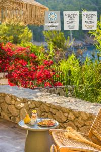 una mesa con un plato de comida junto a una pared de piedra en Chromata Assos Villas Kefalonia en Asos