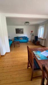 un soggiorno con un divano blu e un tavolo di Ferienhaus Astrid 25196 a Bunde