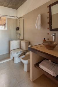 a bathroom with a toilet and a shower and a sink at Complejo il Pensiero Punta del Diablo in Punta Del Diablo