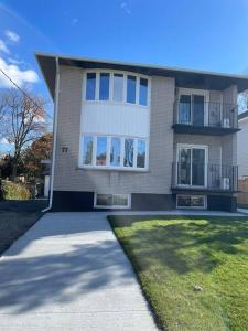 a large brick house with windows and a driveway at Spacious 3 bedroom apartment close Fairview! in Kitchener