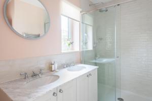baño con 2 lavabos y ducha de cristal en White Horses en Salcombe