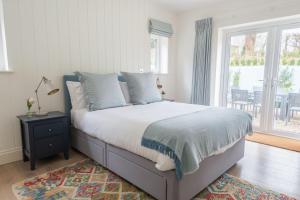 1 dormitorio con 1 cama y ventana con patio en White Horses en Salcombe