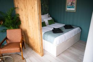 una piccola camera da letto con un letto e una sedia di LE PETIT LH - PLAGE - B'PAM a Le Havre