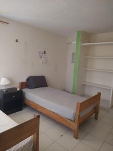 a small bedroom with a bed and shelves at CASA BUGAMBILIAS in Cancún