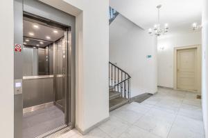 korytarz budynku ze szklanymi drzwiami i schodami w obiekcie Cozy quiet new apartment in Karlin square w Pradze