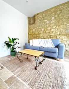 Sala de estar con sofá azul y mesa de centro en Gîtes de charme - Gîtes VITAL, en Peyrus