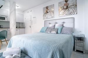 a bedroom with a bed with a blue comforter at Silver horizon Luxury apartment in Nerja +37 photos