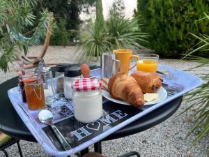 a table with a plate of food and drinks on it at Le Mas des Deux Tilleuls in Sablet
