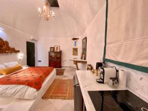 a bedroom with a bed and a kitchen with a counter at Si Brahim studio piscine, Sidi Bou Saïd in Sidi Bou Saïd