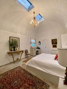 a bedroom with a white bed and a chandelier at Si Brahim studio piscine, Sidi Bou Saïd in Sidi Bou Saïd