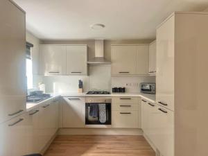 a kitchen with white cabinets and a stove top oven at Modern 3 Bedroom Home In Glasgow in Glasgow