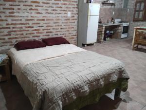 Cama en habitación con pared de ladrillo en Departamento monoambiente en Presidencia Roque Sáenz Peña