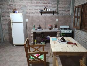 Il comprend une cuisine équipée d'une table en bois et d'un réfrigérateur. dans l'établissement Departamento monoambiente, à Presidencia Roque Sáenz Peña