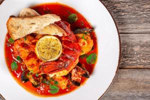 a white bowl of food with seafood and a lemon at Portland Sheraton at Sable Oaks in South Portland