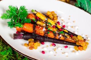 a white plate with carrots and other vegetables on it at Portland Sheraton at Sable Oaks in South Portland