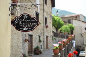 a sign on the side of a building with flowers at San Francesco Suite in Poggio Bustone