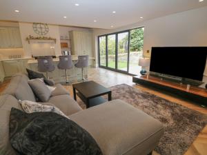 uma sala de estar com um sofá e uma televisão de ecrã plano em Netherdale House em Buxton
