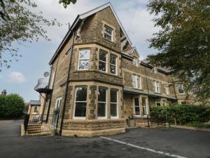 Un gran edificio de ladrillo con un reloj encima. en Netherdale House, en Buxton