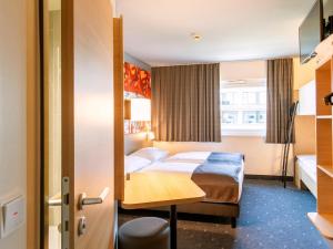 ミュンヘンにあるB＆B ホテル ミュンヘン シティ ウエストのベッドとデスクが備わるホテルルームです。