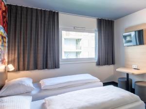 Postel nebo postele na pokoji v ubytování B&B Hotel München City-West