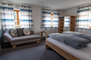 ein Schlafzimmer mit 2 Betten, einem Sofa und einem Stuhl in der Unterkunft Gästehaus Sonner in Dietmannsried