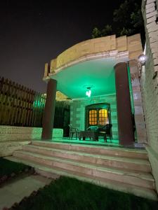 a house with a green lighting in the night at akhnaten villa in Cairo