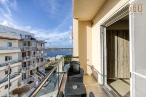uma varanda com cadeiras e vista para o oceano em Spacious, designer 2BR home with Captivating Views by 360 Estates em Mellieħa