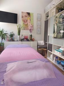 Schlafzimmer mit einem Bett mit rosa Tagesdecke in der Unterkunft Luxuriöse Ferienwohnungen in Königstein an der Elbe