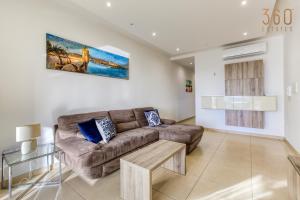 ein Wohnzimmer mit einem Sofa und einem Tisch in der Unterkunft Spacious, designer 2BR home with Captivating Views by 360 Estates in Mellieħa