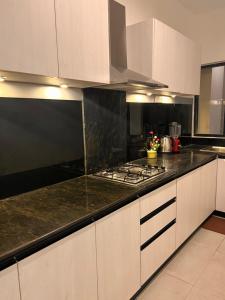 a kitchen with white cabinets and a black counter top at sea esta in Mount Lavinia