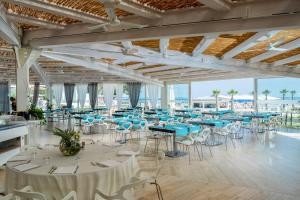a banquet hall with blue tables and white chairs at Isola di Albarella in Isola Albarella