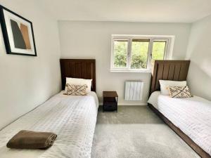 a bedroom with two beds and a window at Ideal 2 Bedroom Glasgow Home in Glasgow