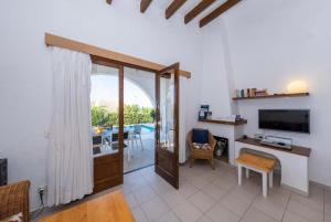 sala de estar con escritorio, TV y balcón en Villa Binibels, en Binibeca