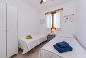 Dos camas en una habitación con paredes blancas y una ventana. en Villa Binibels, en Binibeca 27 fotos más