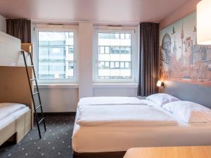 a hotel room with two beds and two windows at B&B Hotel Nürnberg-Hbf in Nürnberg