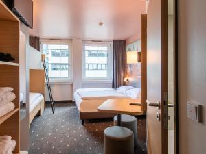 ein Hotelzimmer mit 2 Betten und einem Schreibtisch in der Unterkunft B&B Hotel Nürnberg-Hbf in Nürnberg