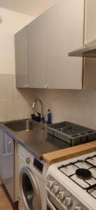 a kitchen with a sink and a washing machine at Richmond London 2 bed room Appartement in London