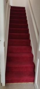a red carpeted staircase with a red carpet at Richmond London 2 bed room Appartement in London