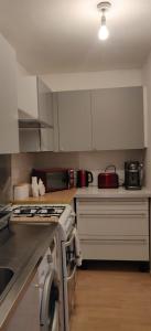 a kitchen with white cabinets and a stove top oven at Richmond London 2 bed room Appartement in London