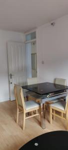 a dining room with a glass table and two chairs at Richmond London 2 bed room Appartement in London