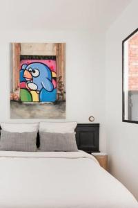 a bedroom with a bed with a painting on the wall at Cabana & Appartement type Loft - Bellecour in Lyon